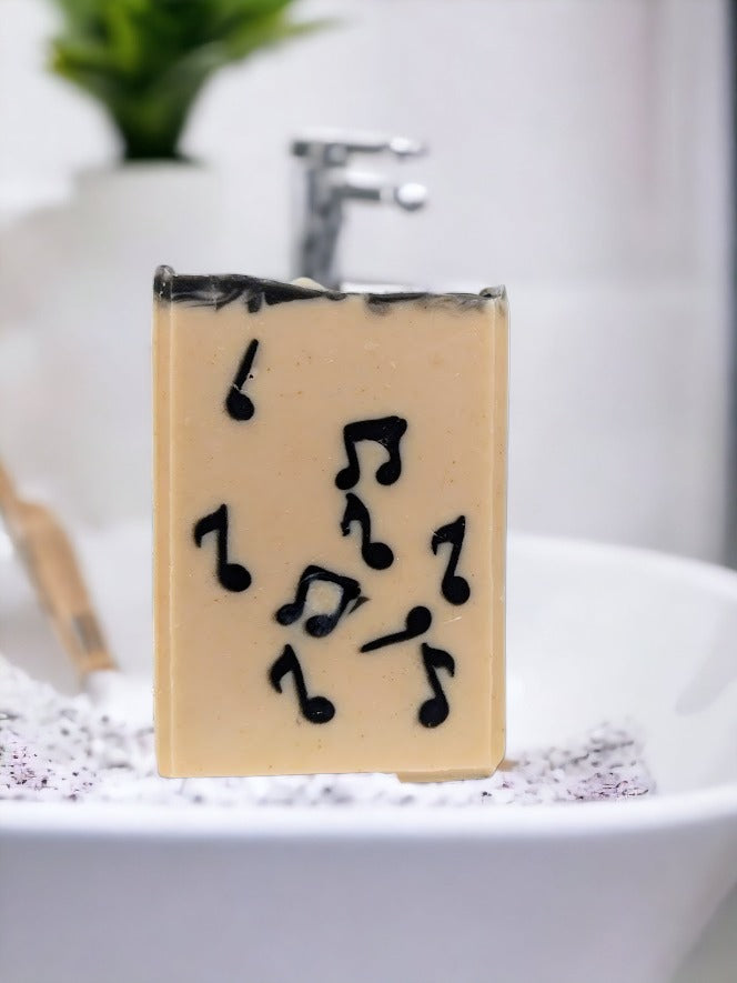 Fun Artisan Tallow Bar Soap, cream background with black Musical Notes embedded throughout. Handcrafted in small batches with goat's milk and a light Bamboo and Teakwood scent along with other skin lovin' ingredients, it's sure to be a hit with music lovers!