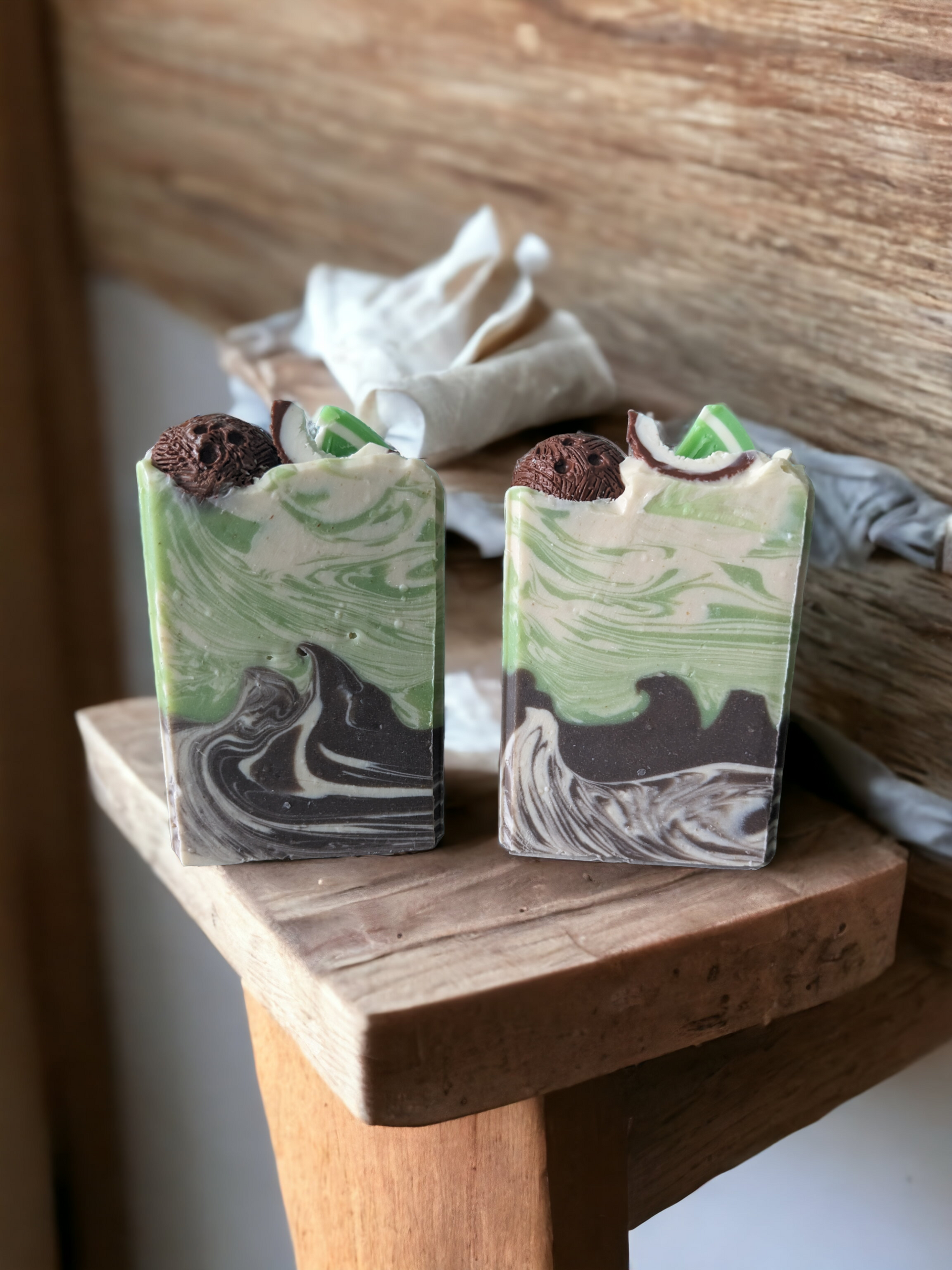 Delightfully scented with Coconut Lime Verbena, and loaded with skin loving ingredients like cocoa, shea, mango and kokum butters, this tropical themed soap will have you dreaming of exotic places!  The soap is decorated with a lime along with a half and a quarter coconut shell.  Body colors are create, lime and brown with a delicate swirl.
