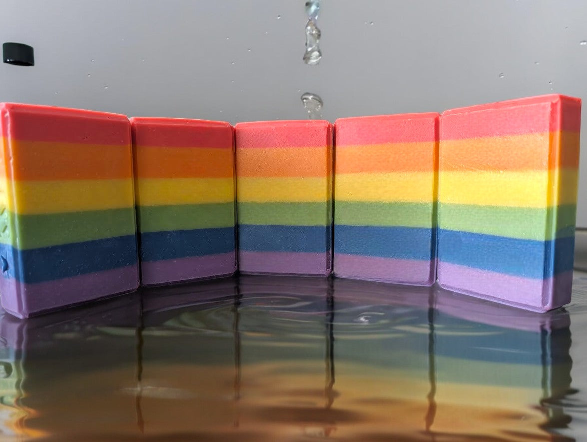 Handcrafted Bar Soap layer with rainbow / Pride flag colors. Bold, fluffly lather and a great addition to your skin care routine. It's personal meaning varies, but the message remains: love is love. Scented with a fresh, clean that evokes the freshness of laundry sun-dried and breeze kissed on a warm summer day!
