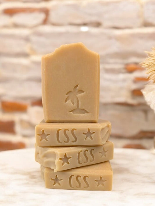 Artisan creamy tan soap with a palm tree stamped on the front of this harmonious, soap boasting the earthy fragrance of Sandwood Patchouli with Hemp Oil and Dead Sea Mud.