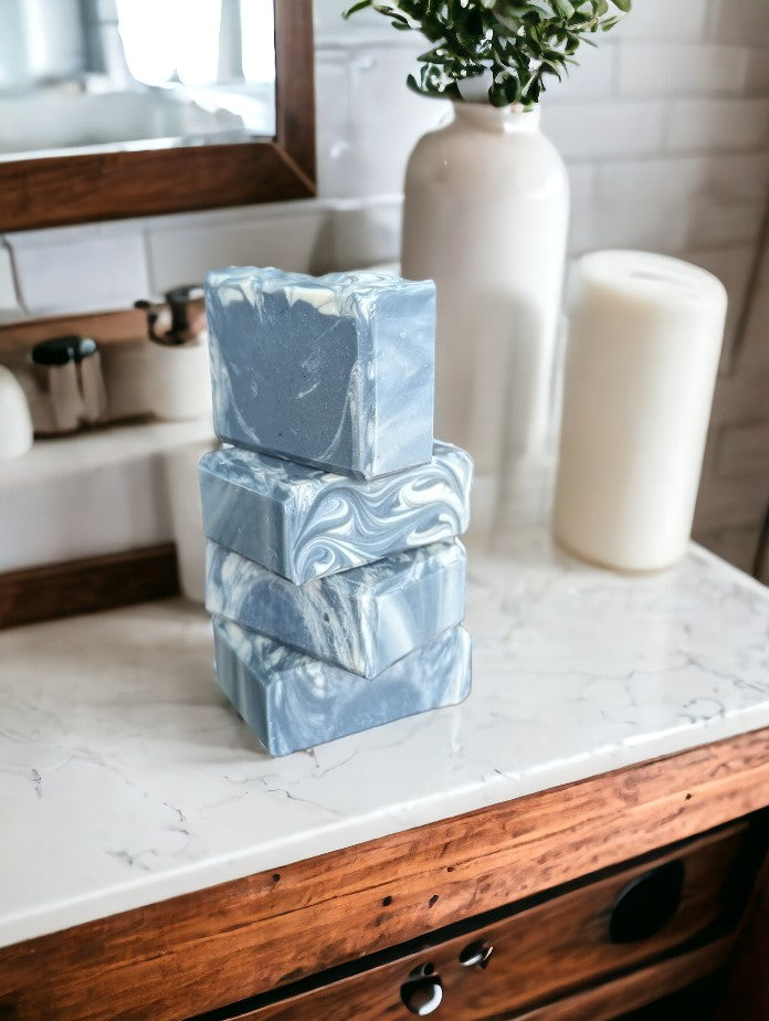 Main soap color is blue with creamy white swirls. Loaded with kaolin clay, colloidal oats and other good for your skin ingredients.  Up your health and beauty care game with Blueberry Burst Soap from Cheryl's Southern Soapery.  Available in 3 sizes.  Small Soap Bar pictured (1"W x 2.5"L x 2"H)