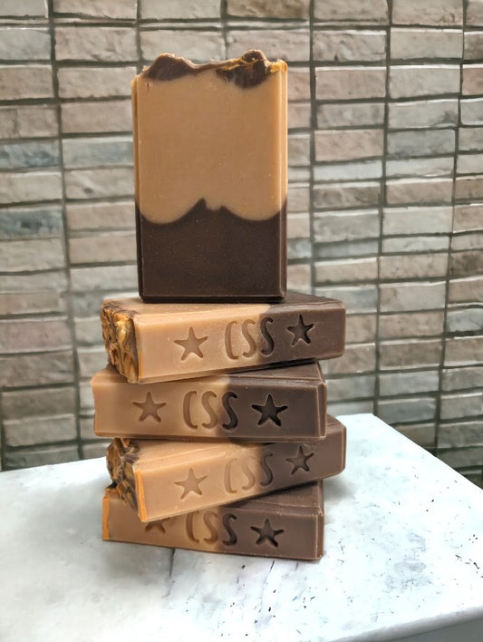 Two-toned soap with dark brown on the bottom and lighter brown on top.  Top adorned with brown and gold swirls.  Made with Goat Milk, colloidal oats and kaolin clay. Available in 3 sizes:  regular bar, small bar and Travel / Guest / Hotel sized bars.