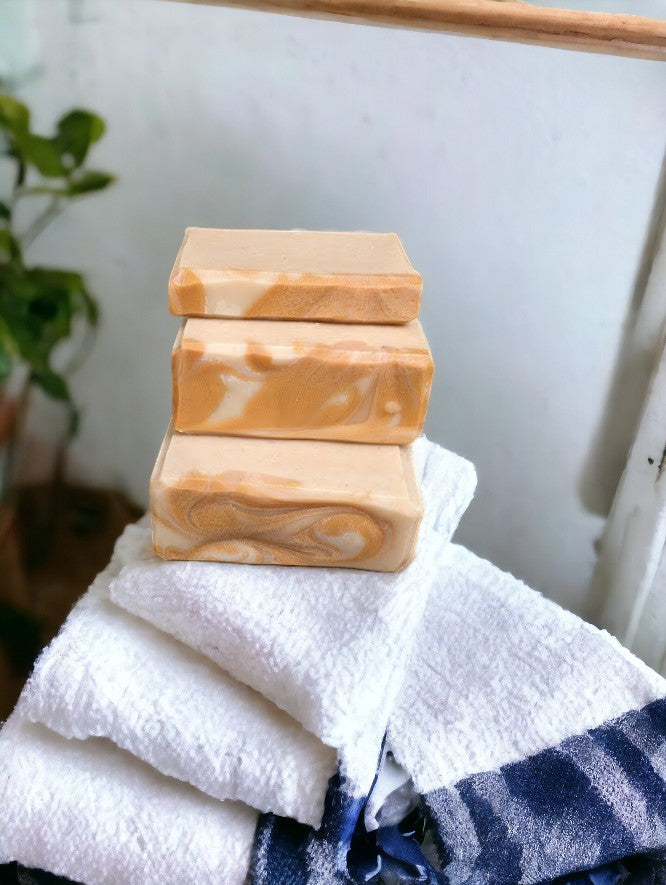 Cold process soap featuring tangerine and tan block coloring separated by a gold mica line.  The scent is a refreshing blend of tangy citrus fruits (lemon, lime, grapefruit) paired with subtle notes of cucumber, pineapple, blackberry, and champagne. Think Burst of Energy* and you'll understand the scent. Available in regular size, small size and travel / guest size.