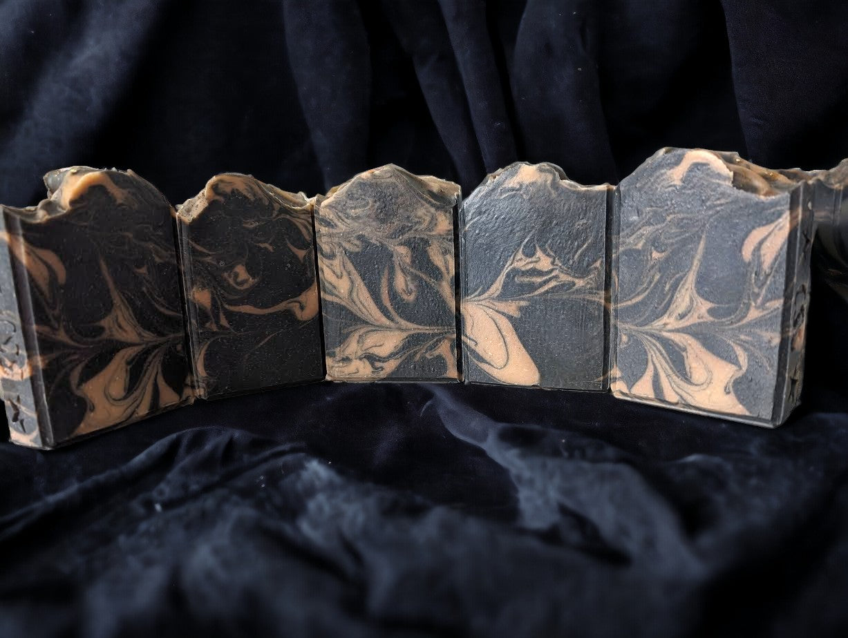 Black soap with gold swirls.  Activated Charcoal, Kaolin Clay, Colloidal Oats and Coconut contribute to this bubbly Lavender and Black Amber Fragranced Bar Soap.