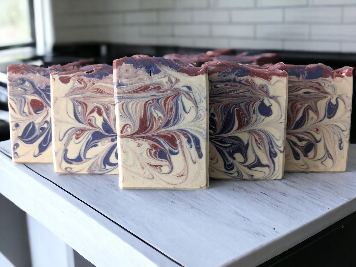 Handcrafted goat milk soap scented with Lavender essential oil.  Features purple and burgandy swirls against an off white background.  Creamy goat milk, and a combination of cocoa, shea, mango, and kokum butters, this bar soap is truly indulgent.