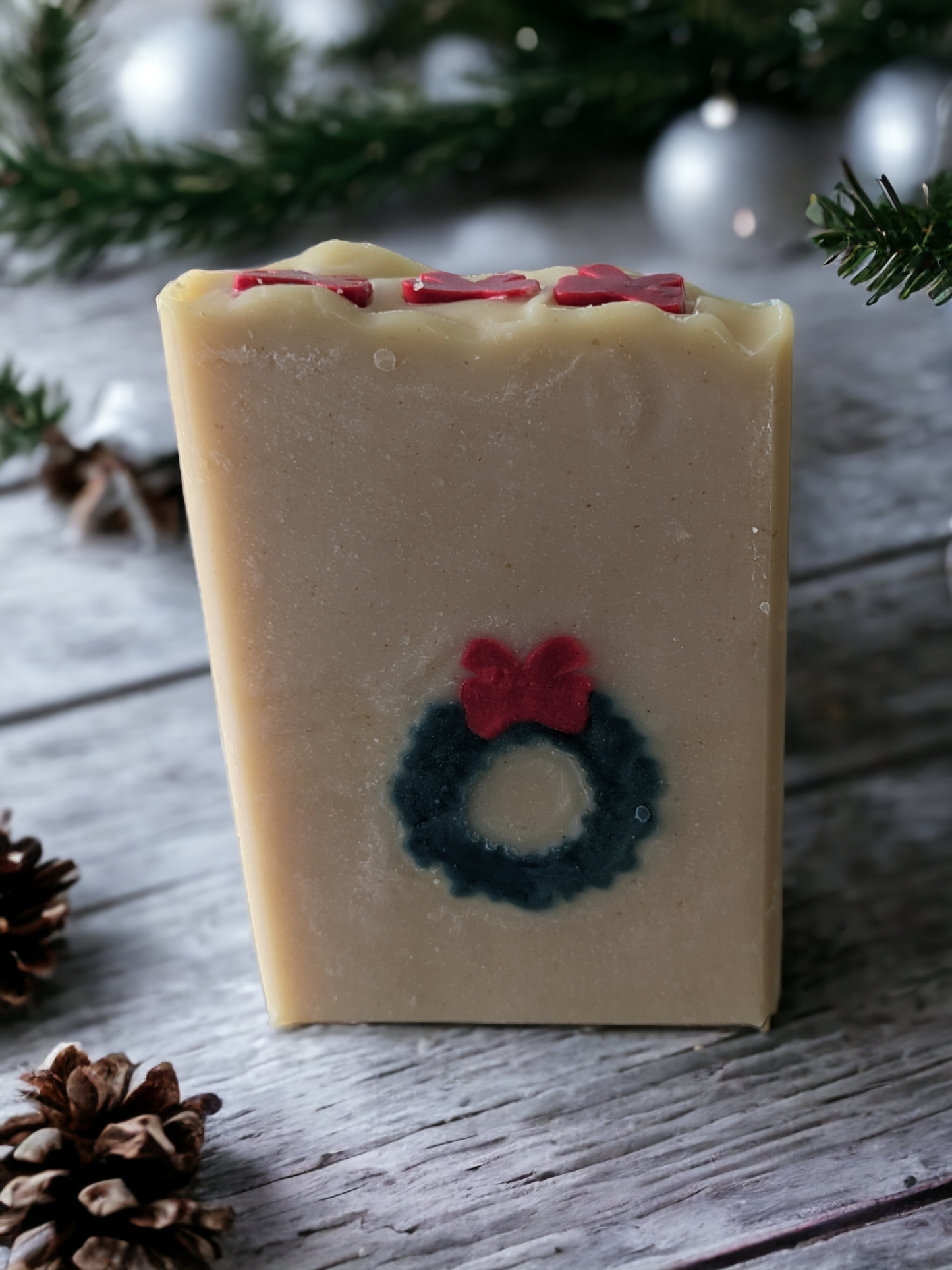 Delightful handmade, decorative Christmas soap bar. This bar features a green wreath and red ribbon that goes through the entire soap bar (from front to back)! Scented with Evergreen Forest fragrance oil, it's perfect for bringing that special festive something to any bathroom! So, ‘tis the season to be merry—get your Wreath of Green soap bar today!