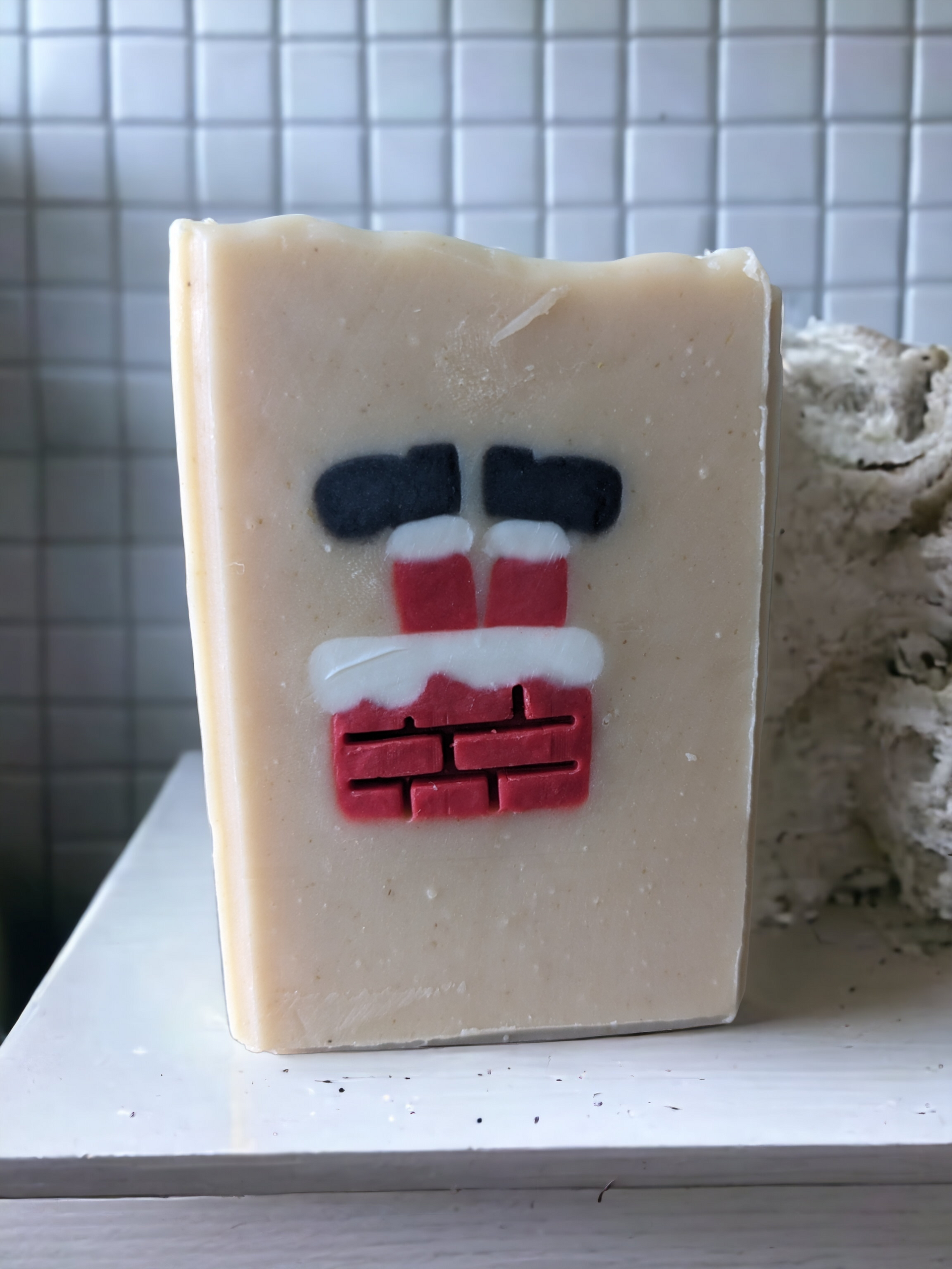 Christmas soap scented with Peppermint Stick fragrance oil. This delightful holiday tallow soap features an embed of Santa Santa stuck in a chimney with his feet in the air.  The embed is throughout the entire width of the soap.  This handcrafted, decorative soap will make your daily washing a tad more cheerful and merry.