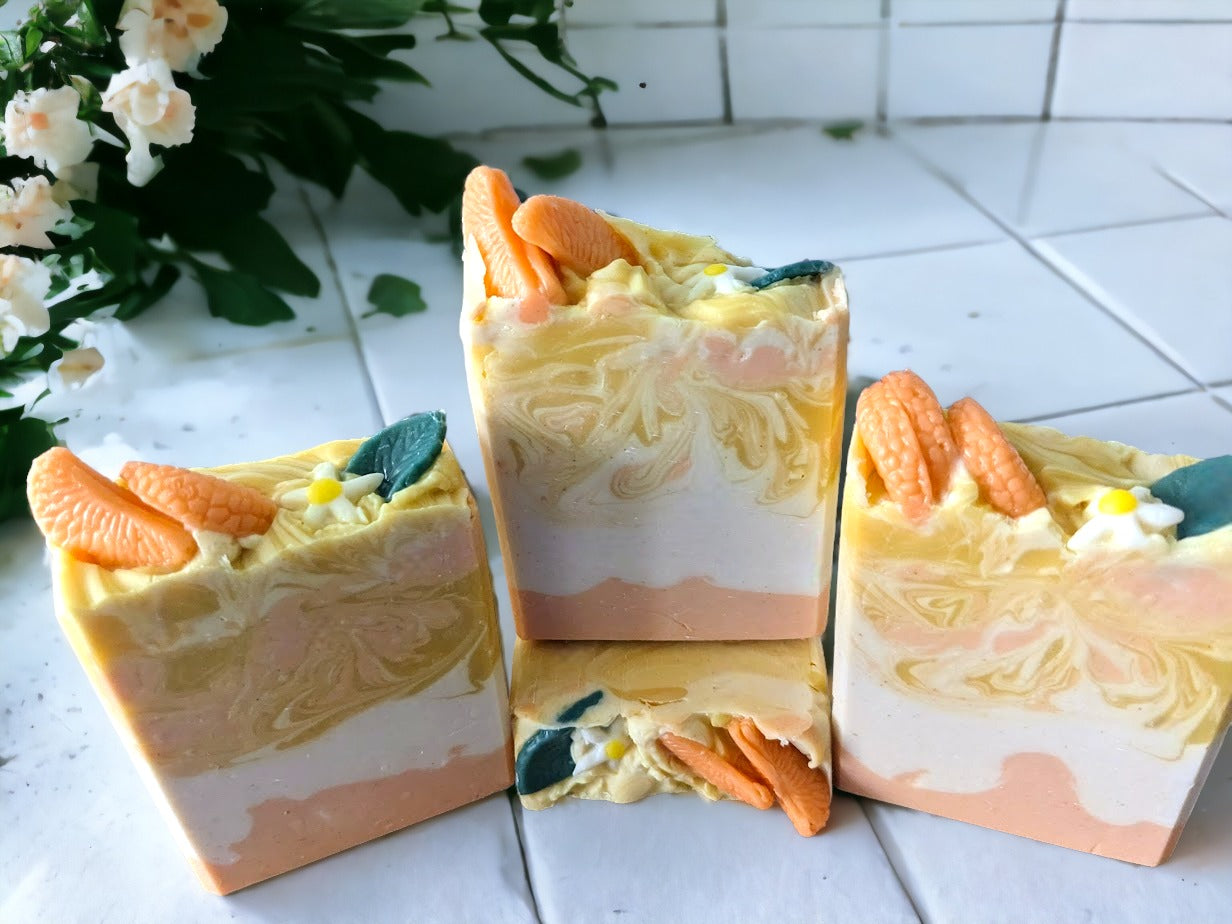 Tangerine Dream Soap! This soap is topped with tangerine wedges, a small white tree bud and leaf. The body of the soap has 3 layers: bottom and middle: solid tangerine and white layers and the top layer has swirls of white, tangerine and yellow. This handmade soap will leave you feeling refreshed and revitalized. Our blend of luxury oils and butters is sure to make you "peel" good!