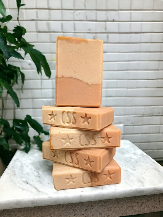 Handcrafted, cold process soap features tangerine and tan block coloring separated by a gold mica line along with a refreshing blend of tangy citrus fruits (lemon, lime, grapefruit) paired with subtle notes of cucumber, pineapple, blackberry, and champagne. Not only does it smell FANTASTIC and have a creamy and luxurious lather (and lots of it too!!)