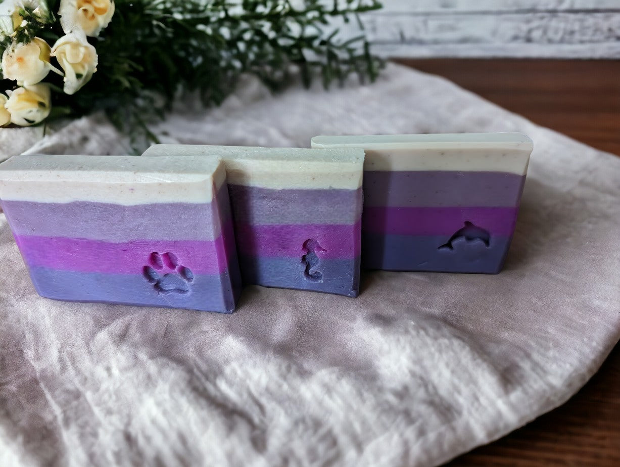 This Handcrafted soap features 7 layers of purple. 3 Sizes:  Regular bar, Small bar and Travel / Guest size bar.  aLoved & used by both men & women, the fragrance in this soap is an empowering, masculine fusion of mahogany, cedar, geranium and resinous woods delightfully supplemented with hints of lavender all wrapped up in a skin loving, bubbly bar.  Think BBW White Barn® Mahogany Teakwood and you'll understand the scent.