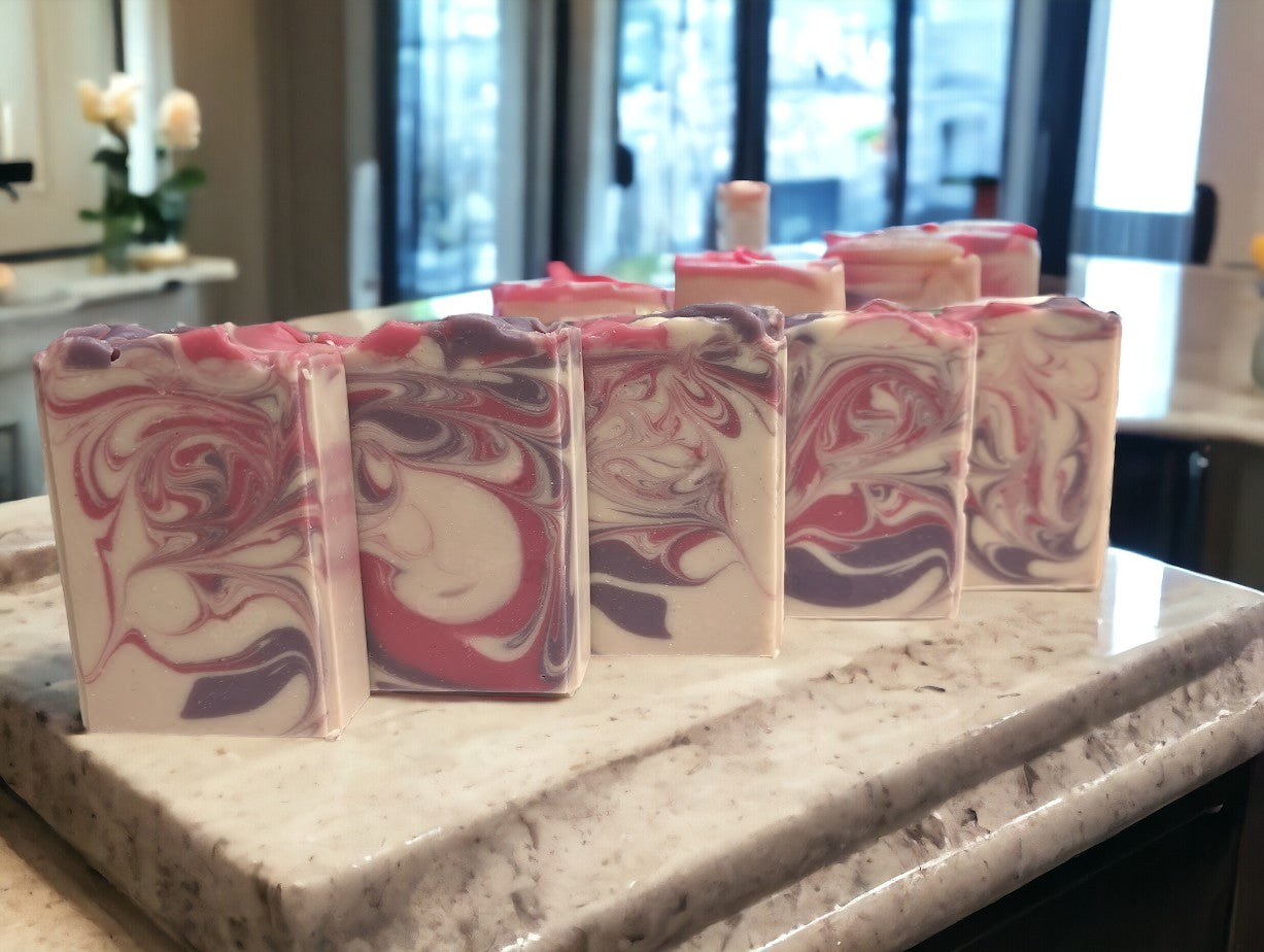 Creamy white handcrafted soap with delicate swirls of pink and purple.  Top adorned with pink and purple swirls.  Great for your skin care routine.  Featuring Coconut Milk, colloidal oats and kaolin clay. Available in 3 sizes:  regular bar, small bar and Travel / Guest / Hotel sized bars.