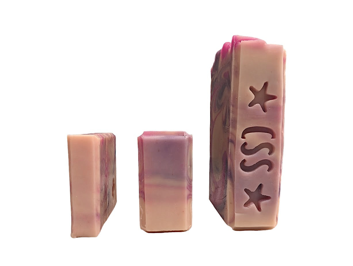 Creamy white handmade soap with delicate swirls of pink and purple.  Top adorned with pink and purple swirls.  Good Soap and great for your bath routine.  Featuring Coconut Milk, colloidal oats and kaolin clay. Available in 3 sizes:  regular bar, small bar and Travel / Guest / Hotel sized bars.