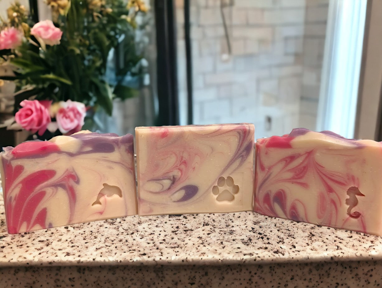 Creamy white handmade soap with delicate swirls of pink and purple.  Top adorned with pink and purple swirls.  Good Soap and great for bath and beauty routine.  Featuring Coconut Milk, colloidal oats and kaolin clay. Available in 3 sizes:  regular bar, small bar and Travel / Guest / Hotel sized bars.
