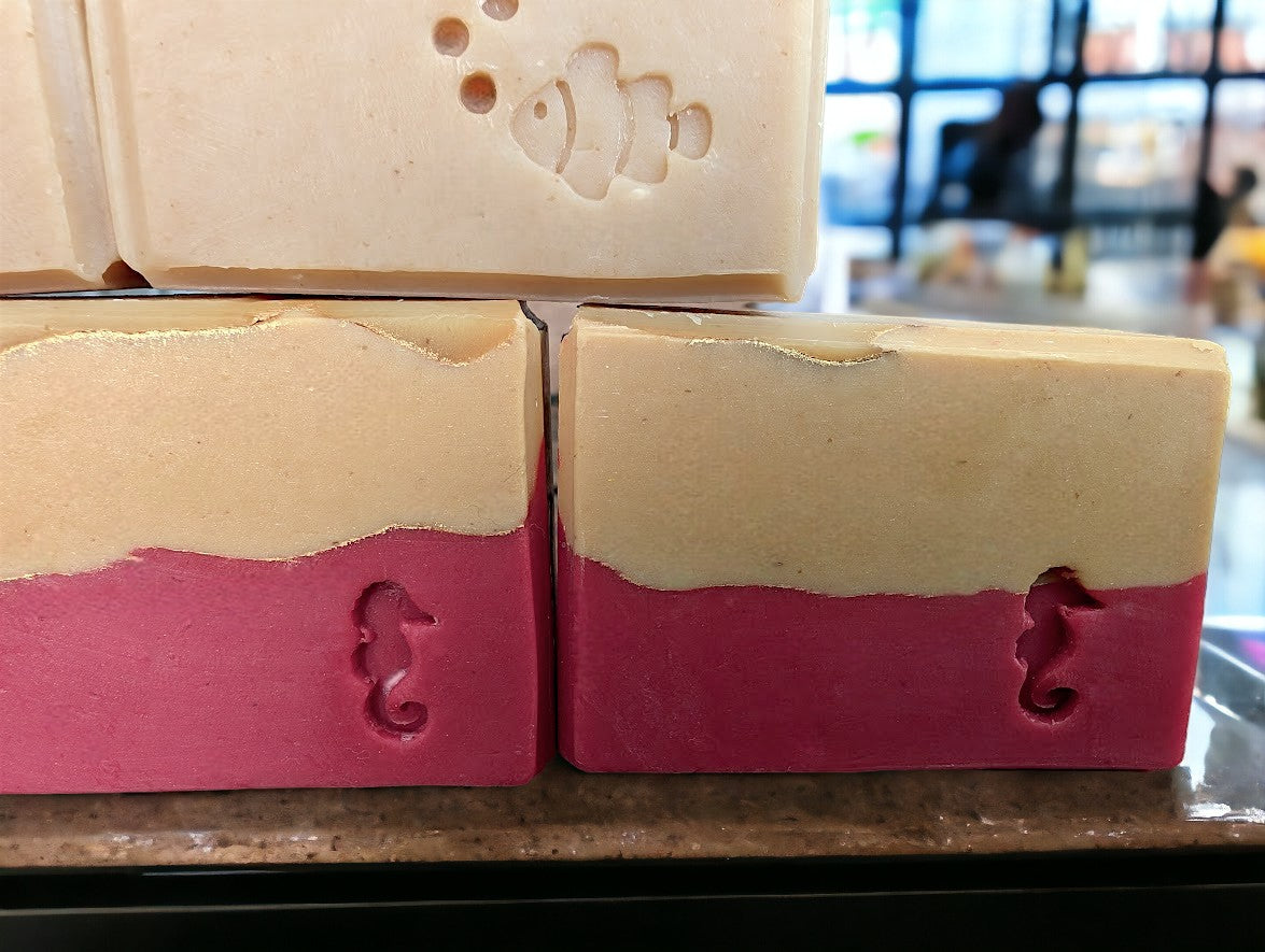 Beautiful handcrafted cold process Avocado Oil and Goat milk soap.  3 layers of Red, peach and cream separate by gold lines.  Red, peach and gold swirls adorn the top of the soap.  Fragranced with a  Strawberry peach champagne to up your skin care and soap game.  Available in 3 sizes:  Regular soap bar size, Small bar and Travel/Guest or Hotel soap size.