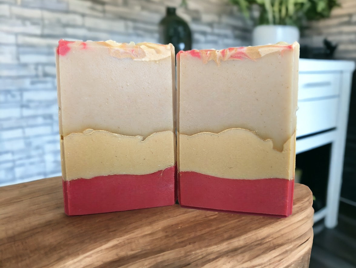 Beautiful handcrafted Avocado Oil and Goat milk soap.  3 layers of Red, peach and cream separate by gold mica lines.  Red, peach and gold swirls adorn the top of the soap.  Fragranced with a luxurious Strawberry peach champagne to up your skin care game.