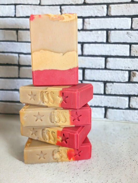 Beautiful 3 layered soap.  Layers of Red, peach and cream separate by gold mica lines.  Red, peach and gold swirls adorn the top of the soap.  Fragranced with a luxurious Strawberry peach champagne to up your bath and beauty product game.