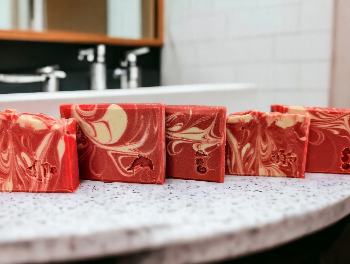 Cold processed soap bar with strawberry red main color with white swirls.  Small and Travel bars stamped with dolphin, clown fish or sea horse.  Features Avocado Oil, Colloidal Oats and Kaolin Clay.  Fresh Picked Strawberry fragrance oil.  