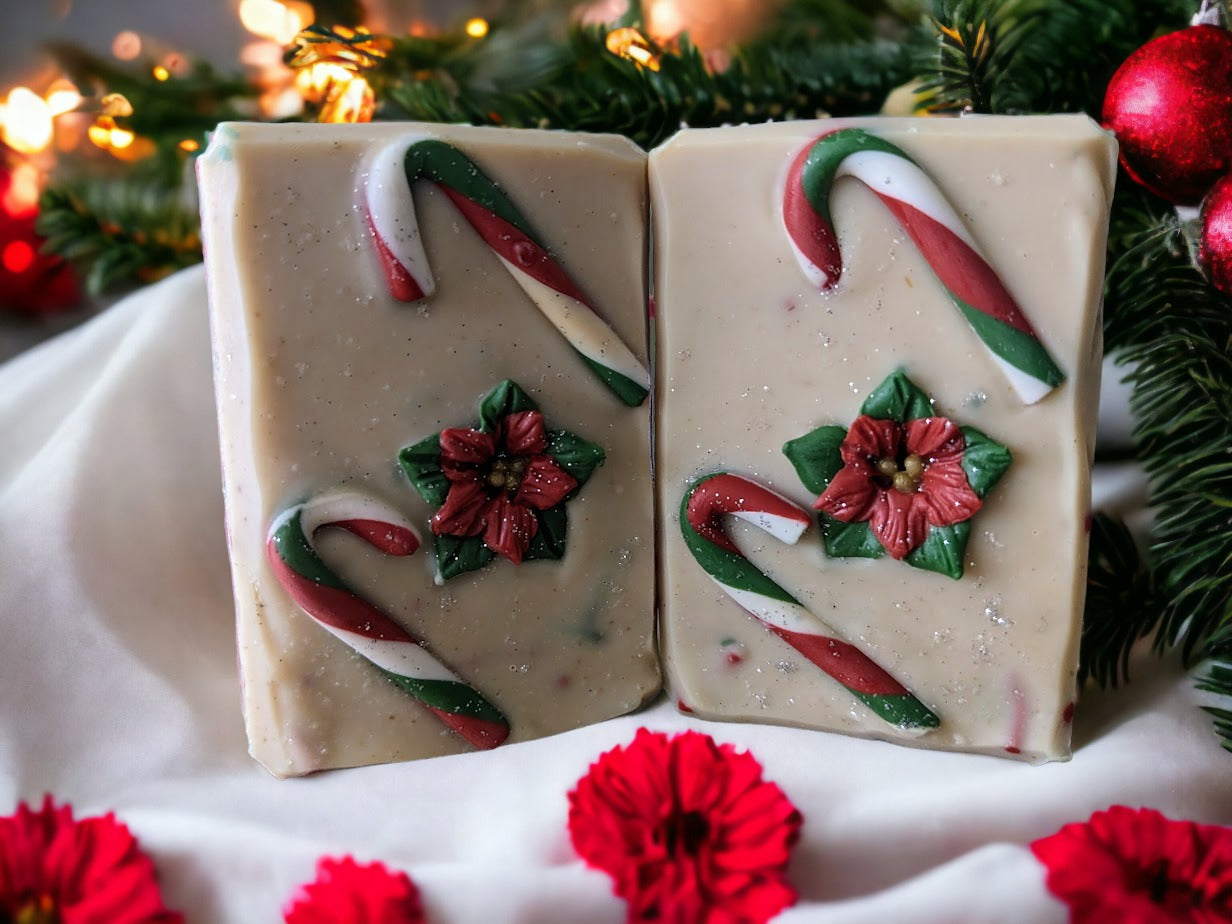 Handmade bar Soap decorated with Candy Canes and a poinsettia on top.  Body of the soap is layered starting with green, then red and a creamy white with red and green soap sprinkles and a little sparkle.