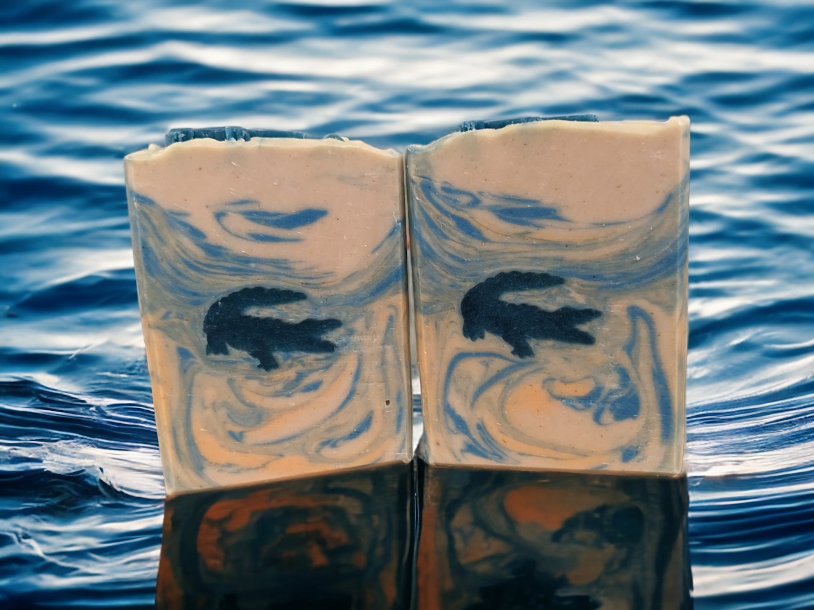 Let your imagination run wild with our Fun Alligator Tallow Bar Soap. This skin lovin soap features soapy alligator embeds with blue and orange swirly water.  Handcrafted in small batches with kaolin clay, colloidal oats, soap nuts, goat's milk and a hint of Kentucky Bourbon scent, this bar soap will leave you feelin' refreshed all day and ready to take on whatever the wild throws at you.