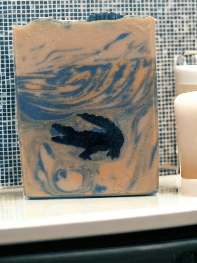 Let your imagination run wild with our unique, Fun Alligator Tallow Bar Soap. This skin lovin soap features soapy alligator embeds with blue and orange swirly water.  Handcrafted in small batches with kaolin clay, colloidal oats, soap nuts, goat's milk and a hint of Kentucky Bourbon scent, this bar soap will leave you feelin' refreshed all day and ready to take on whatever the wild throws at you.