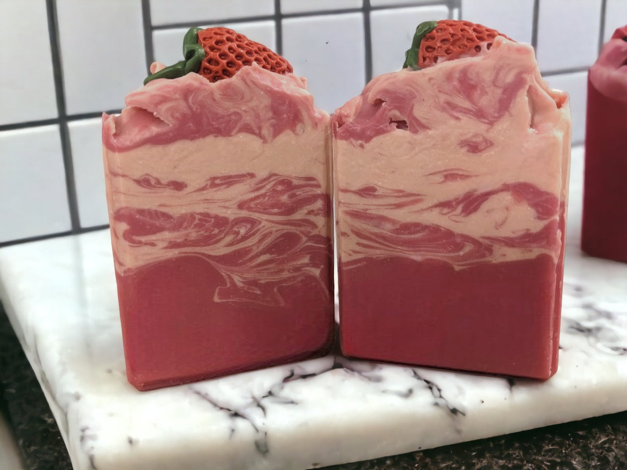 Enjoy the scent fresh picked strawberries with our luxurious Butter Soap Bar! This delightful 4 butter strawberry bar will make you feel like you're right in the middle of a strawberry patch. Topped with a soap strawberrry and a body of red and cream swirls, this handcrafted soap bar is loaded with skin lovin' ingredients, your skin will feel refreshed with a soft silky finish.