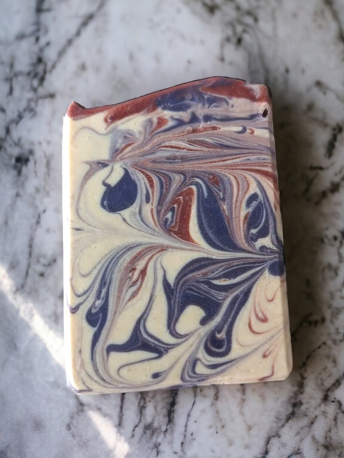 Handmade goat milk bar soap scented with Lavender essential oil.  Features purple and burgandy swirls against an off white background.  Creamy goat milk, and a combination of cocoa, shea, mango, and kokum butters, this soap is truly indulgent. 