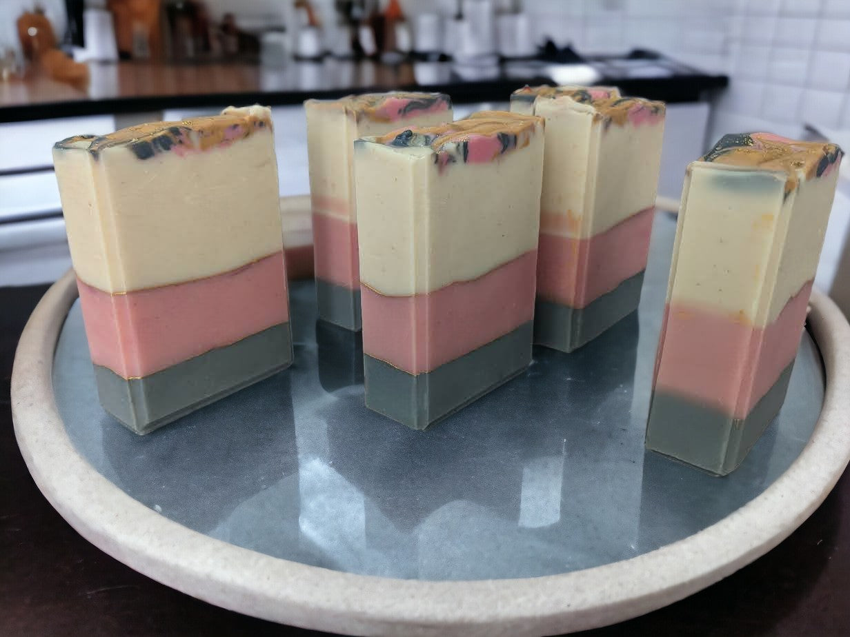 This beautiful handmade soap boasts Cocoa, Shea, Mango and Kokum butters and has layers of white, pink, and grey that are separated by elegant gold mica lines. Fragrance and essential oil blend (think Coco Mademoiselle*).  This soap will definitely up your skincare game. 