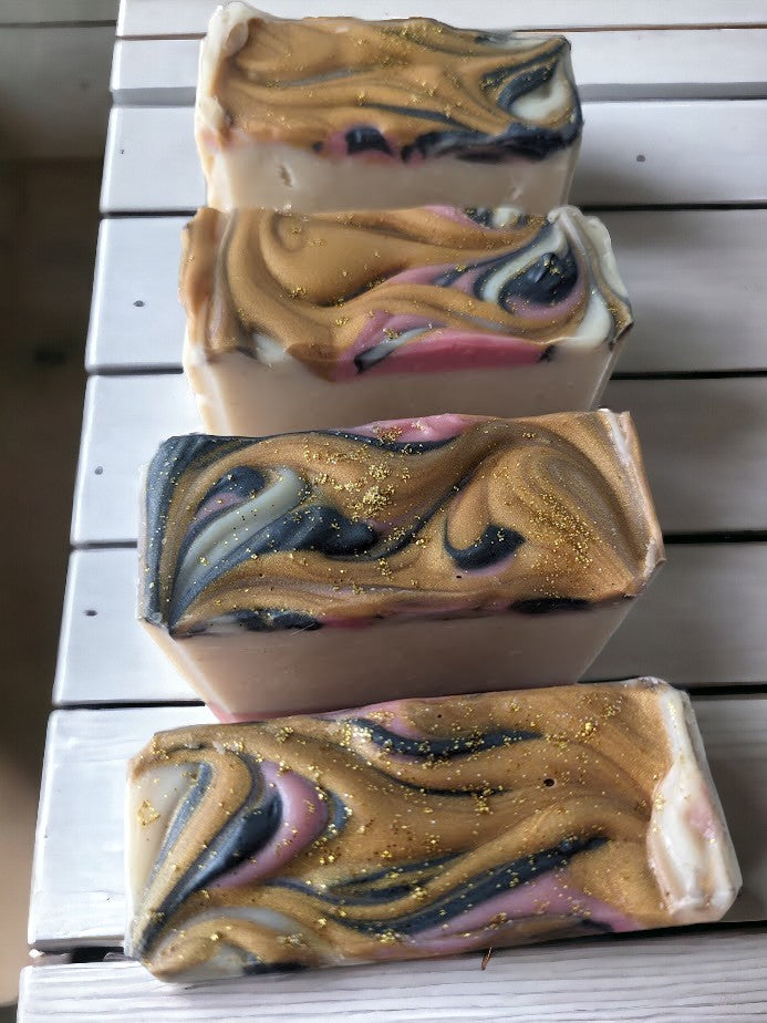 This beautiful artisan soap boasts Cocoa, Shea, Mango and Kokum butters and has layers of white, pink, and grey that are separated by elegant gold mica lines. Fragrance and essential oil blend (think Coco Mademoiselle*).  This soap will definitely up your personal care game or is the perfect gift for that special someone in your life.