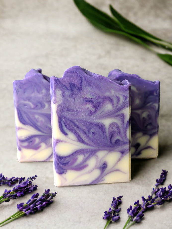 Slide into silky suds with this four butter lavender soap bar. Lovingly handcrafted and lightly scented with lavender essential oil and delicate swirls in shades of purple and cream, you'll be feeling fresh and fabulous after every use!