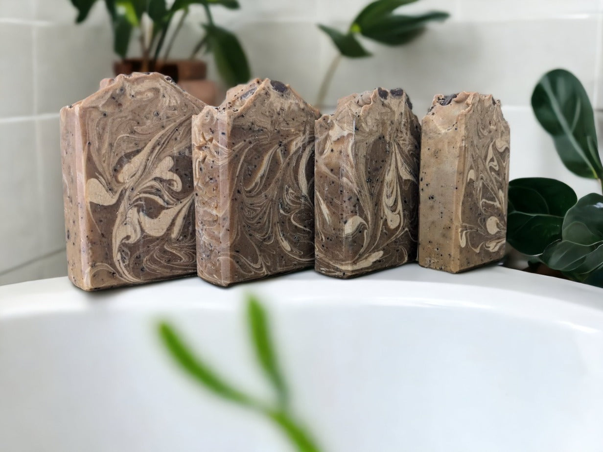 Experience the ultimate with this all-natural and handcrafted coffee soap! The perfect gift for coffee lovers! Natural brown with delicate and creamy swirls, with a pinch of coffee grinds on top and throughout for a gentle exfoliation.  This soap bar will tantalize your senses with its delightful hazelnut coffee scent & rich, bubbly lather. It's brimming with skin loving ingredients that'll give your epidermis a treat.