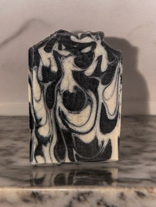 Beautiful and all natural, black and off white sea moss, coconut milk and activated charcoal bar soap. Super rich and bubbly lather, gentle on skin.  This handcrafted soap is a must have for your skin care collection!  Edge Co-pilot tells us that 'Sea moss soap is renowned for its myriad skin health benefits, attributed to the abundant minerals and vitamins in sea moss.' The benefits are extensive. Go ahead and search for it in your preferred internet browser to learn more!