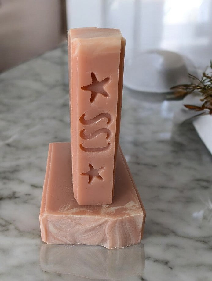 Peach colored bar soap with a palm tree stamp.  Fragrance smells just like a delectably ripe and juicy Georgia peach!! Handcrafted with kaolin clay and colloidal oats, and other skin loving ingredients, this bubbly soap is a perfect addition to your personal care routine.