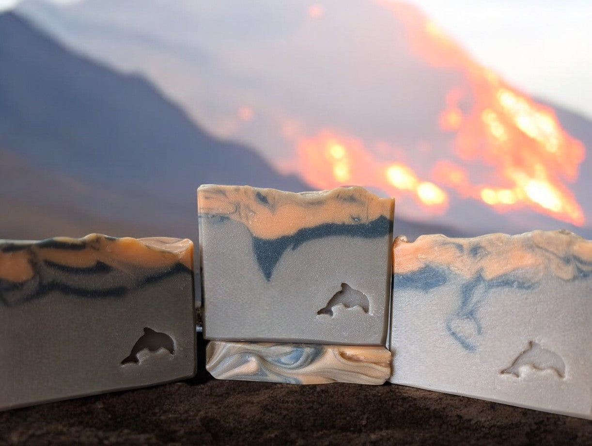 Handcrafted brown volcano goat milk soap adorned with orange and black soap (lava).This is a big bubble bar with a light luxurious lather. Similar to Capri Blue®'s Volcano.  Available in regular bar size, small (or half size) and Hotel, Travel, Guest size.