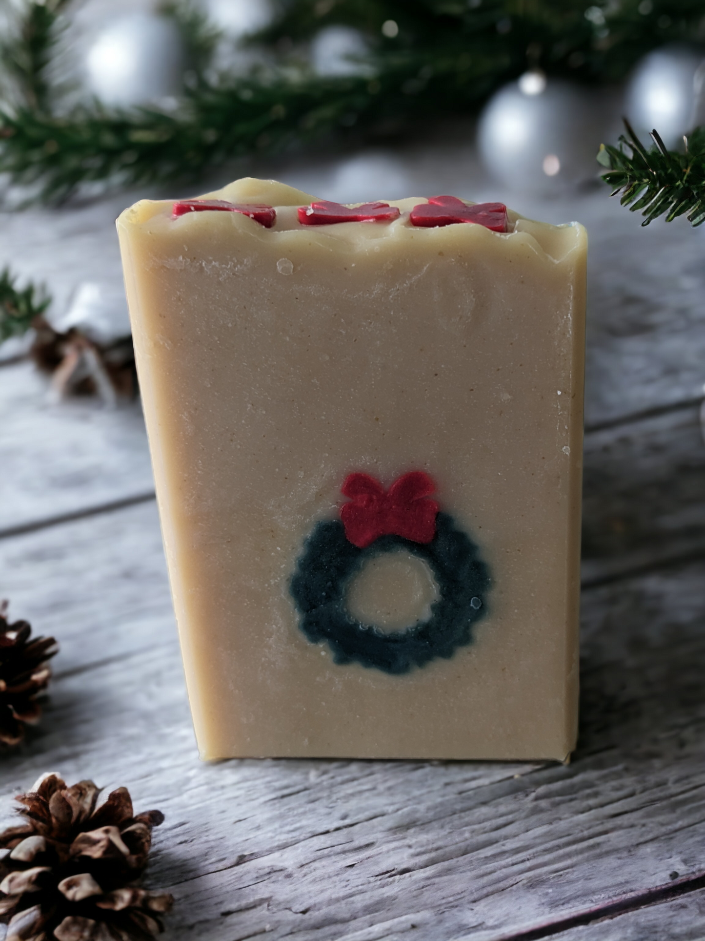 Delightful handmade, decorative Christmas soap bar.  This bar features a green wreath and red ribbon that goes through the entire soap bar (from front to back)!  Scented with Evergreen Forest fragrance oil, it's perfect for bringing that special festive something to any bathroom! So, ‘tis the season to be merry—get your Wreath of Green soap bar today!