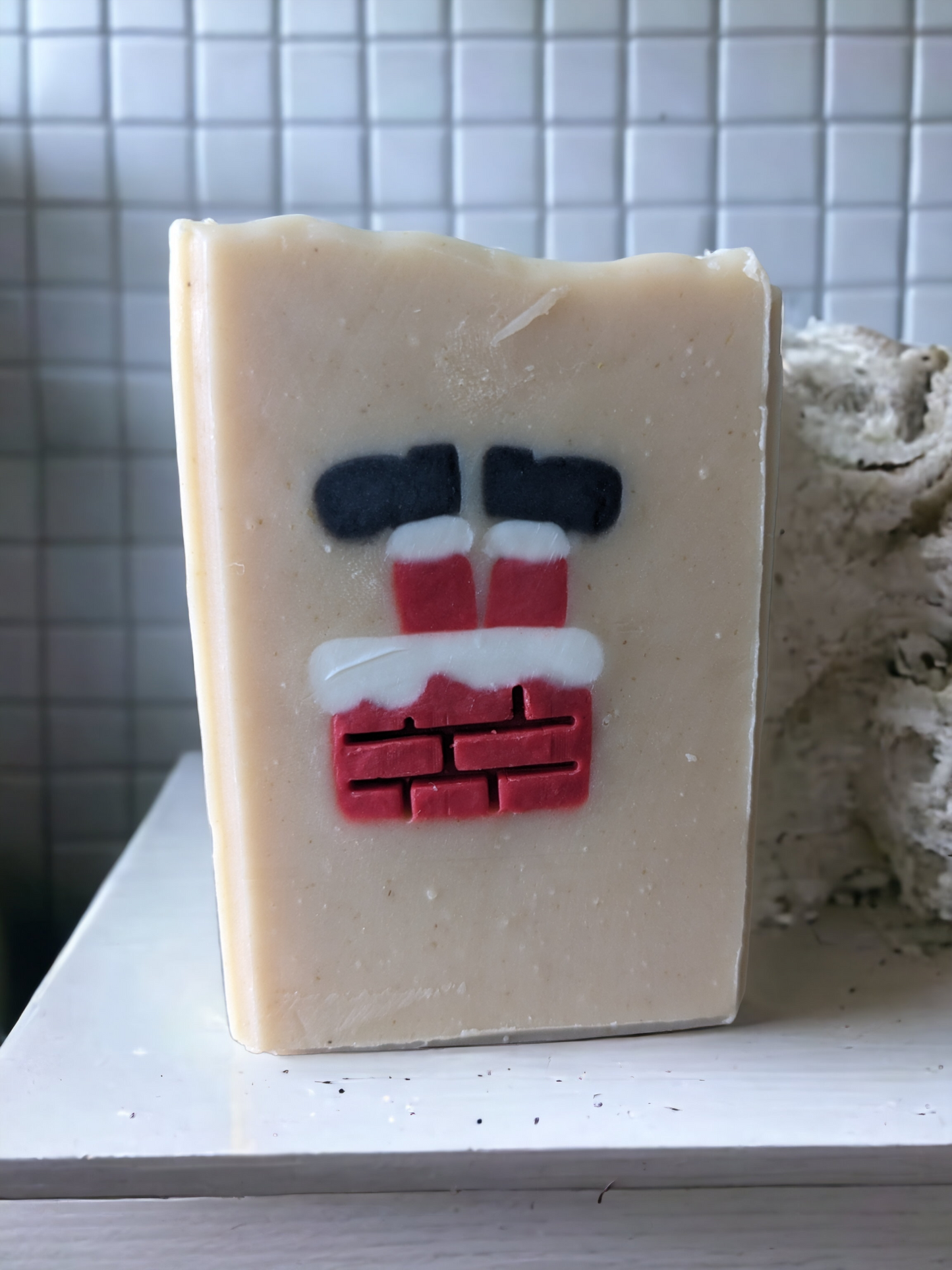 Christmas soap scented with Peppermint Stick fragrance oil. This delightful holiday tallow soap features an embed of Santa Santa stuck in a chimney with his feet in the air.  The embed is throughout the entire width of the soap.  This handcrafted, decorative soap will make your daily washing a tad more cheerful and merry. 