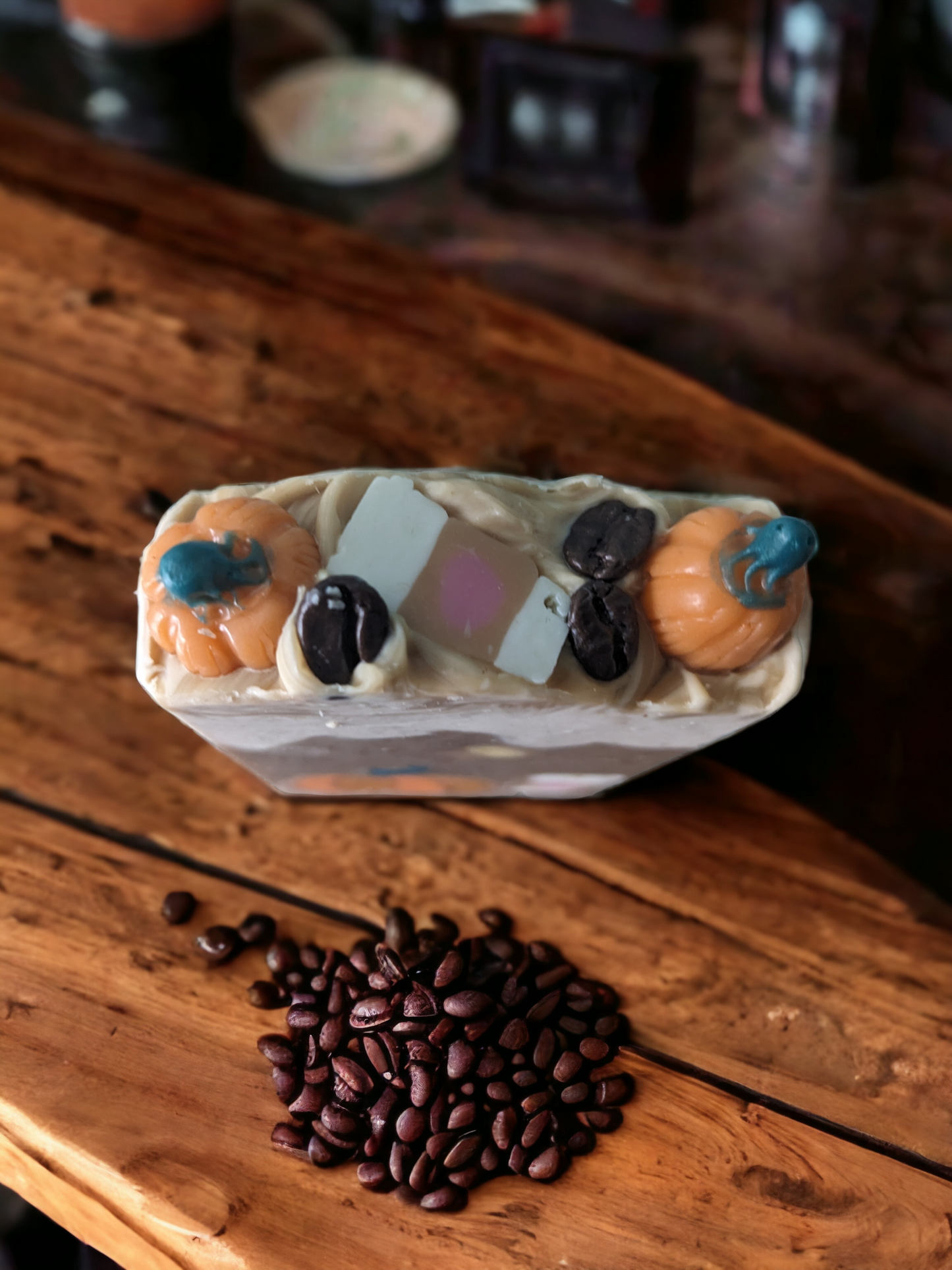 Pumpkin Spice Latte To Go,  Luxury Artisan Bar soap .  The top of the handcrafted soap bar has a creamy white top that is decorated with delightful pumpkins, a to go coffee cup and coffee beans.  The body of  the bar of soap has light latte brown with a pumkpin and to go coffee cup that go through the width of the soap.