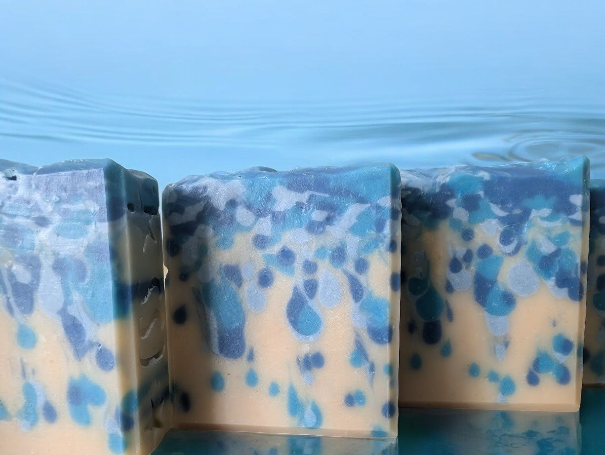 Bubbly goat milk soap scented with Black Raspberry Vanilla. Handcrafted with blue drop swirls on a cream base, evoking ocean water or sea pearls. Enriched with Goat Milk, Kaolin Clay, and Colloidal Oats for a rich, bubbly lather. Perfect for body and hand washing.