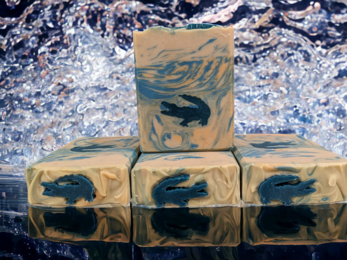 Ready for adventure, let your imagination run wild with our unique, Fun Alligator Tallow Bar Soap. This skin lovin soap features soapy alligator embeds with blue and orange swirly water.  Handcrafted in small batches with kaolin clay, colloidal oats, soap nuts, goat's milk and a hint of Kentucky Bourbon scent it’s got a creamy and sudsy lather that will leave you feelin' refreshed all day and ready to take on whatever the wild throws at you.