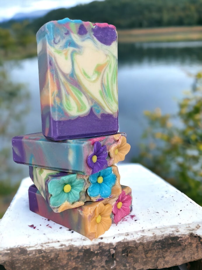 Delightful spring soap scented with midnight peonies.  Soap flowers in spring colors adorn the top of this luxury soap bar! Gentle swirls throughout the soap in the same color as the flowers in purple, pink orange, green and caribbean blue. Handcrafted with skin-loving Shea, Mango, Cocoa and Kokum butters, you'll feel as fresh as a spring morning! And the gorgeous soap flowers and swirl design make it the perfect gift for any occasion!