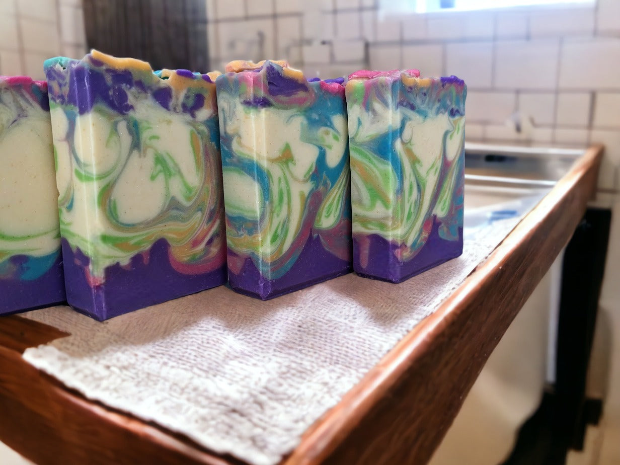 Soap flowers in spring colors adorn the top of this luxury soap bar! Gentle swirls throughout the soap in the same color as the flowers in purple, pink orange, green and caribbean blue. Handcrafted with skin-loving Shea, Mango, Cocoa and Kokum butters, you'll feel as fresh as a spring morning! And the gorgeous soap flowers and swirl design make it the perfect gift for any occasion!  Scented with midnight peonies.